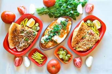 Delicious meat kebab with fresh vegetable salad served with variety of Turkish dishes and appetizers. Top view of assorted Turkish food and meze, tasty and healthy Mediterranean cuisine.