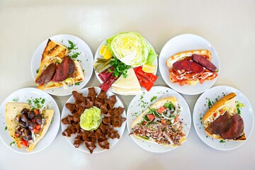 Delicious meat kebab with fresh vegetable salad served with variety of Turkish dishes and appetizers. Top view of assorted Turkish food and meze, tasty and healthy Mediterranean cuisine.
