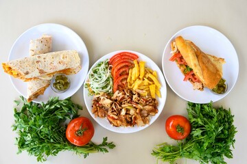 Delicious meat kebab with fresh vegetable salad served with variety of Turkish dishes and appetizers. Top view of assorted Turkish food and meze, tasty and healthy Mediterranean cuisine.