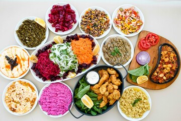 Delicious meat kebab with fresh vegetable salad served with variety of Turkish dishes and appetizers. Top view of assorted Turkish food and meze, tasty and healthy Mediterranean cuisine.