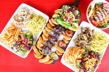 Delicious meat kebab with fresh vegetable salad served with variety of Turkish dishes and appetizers. Top view of assorted Turkish food and meze, tasty and healthy Mediterranean cuisine.