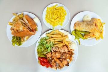 Delicious meat kebab with fresh vegetable salad served with variety of Turkish dishes and appetizers. Top view of assorted Turkish food and meze, tasty and healthy Mediterranean cuisine.