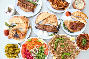 Delicious meat kebab with fresh vegetable salad served with variety of Turkish dishes and appetizers. Top view of assorted Turkish food and meze, tasty and healthy Mediterranean cuisine.