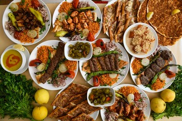 Delicious meat kebab with fresh vegetable salad served with variety of Turkish dishes and appetizers. Top view of assorted Turkish food and meze, tasty and healthy Mediterranean cuisine.