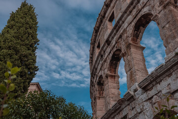 Beautiful roman colloseum or amphiteatre in Pula on a sunny summer evening with romantic feeling. Details parts of beautiful roman structure in golden light.