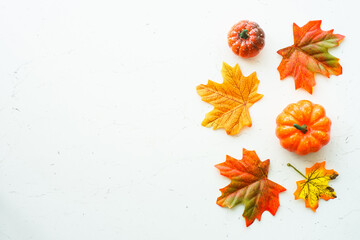 Fall flat lay background at white marble table. Pumpkins and fall leaves, holiday decorations.