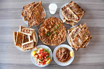 Traditional Turkish cuisine. Pizza, pita, pidesi, sucuk, hummus, kebab. Many dishes on the table. Serving dishes in restaurant. Background image. Top view, flat lay