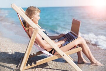 Portrait of happy young woman relaxing on tropical beach