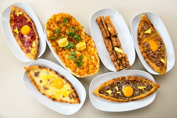 Traditional Turkish cuisine. Pizza, pita, pidesi, sucuk, hummus, kebab. Many dishes on the table. Serving dishes in restaurant. Background image. Top view, flat lay