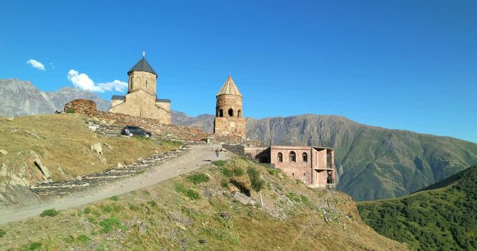 Monastery on a hill at the foot of Mount Kazbek. Trinity Church in Gergeti, Georgia. Aerial view. The Caucasus Mountains