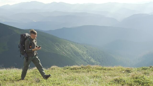 A man is looking for a network on a phone in the mountains, while hiking. A tourist with a smartphone is trying to make a call. There is no cellular connection. High quality 4k footage