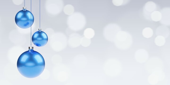Three blue christmas bauble balls hanging in front of bokeh background with copy space, christmas or new year template
