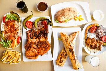 Delicious meat kebab with fresh vegetable salad served with variety of Turkish dishes and appetizers. Top view of assorted Turkish food and meze, tasty and healthy Mediterranean cuisine.