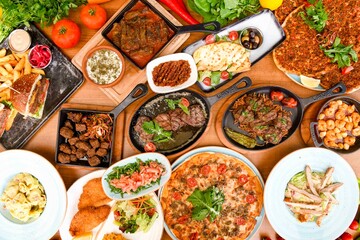 Delicious meat kebab with fresh vegetable salad served with variety of Turkish dishes and appetizers. Top view of assorted Turkish food and meze, tasty and healthy Mediterranean cuisine.