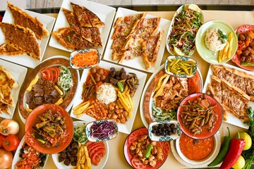 Delicious meat kebab with fresh vegetable salad served with variety of Turkish dishes and appetizers. Top view of assorted Turkish food and meze, tasty and healthy Mediterranean cuisine.