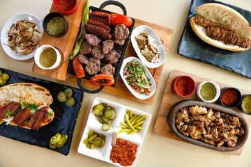 Delicious meat kebab with fresh vegetable salad served with variety of Turkish dishes and appetizers. Top view of assorted Turkish food and meze, tasty and healthy Mediterranean cuisine.