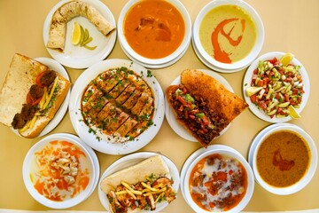 Delicious meat kebab with fresh vegetable salad served with variety of Turkish dishes and appetizers. Top view of assorted Turkish food and meze, tasty and healthy Mediterranean cuisine.