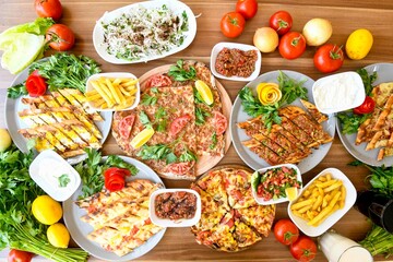 Delicious meat kebab with fresh vegetable salad served with variety of Turkish dishes and appetizers. Top view of assorted Turkish food and meze, tasty and healthy Mediterranean cuisine.