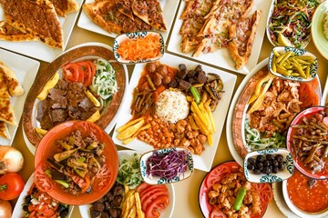 Traditional Turkish cuisine. Pizza, pita, pidesi, sucuk, hummus, kebab. Many dishes on the table. Serving dishes in restaurant. Background image. Top view, flat lay