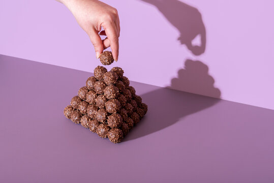 Chocolate truffles tower on a purple table in a bright light