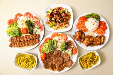 Delicious meat kebab with fresh vegetable salad served with variety of Turkish dishes and appetizers. Top view of assorted Turkish food and meze, tasty and healthy Mediterranean cuisine.
