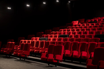 salle de cinéma ou de spectacle avec fauteuils rouges et noirs