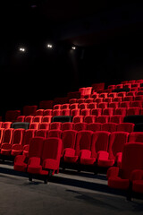salle de cinéma avec des sièges rouges et des sièges duo noirs