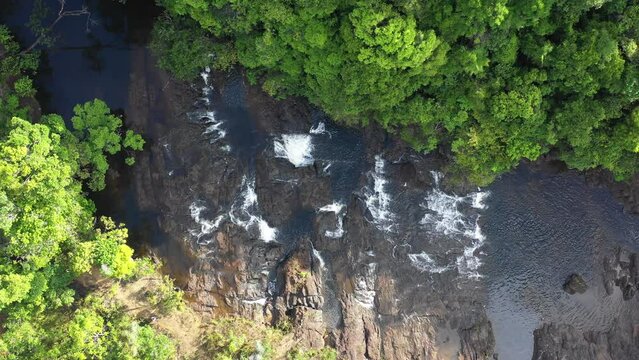 aerial image flying over waterfall in the middle of the forest