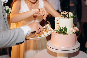 bride and groom holding wedding cake