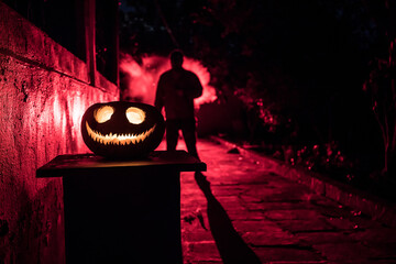 Pumpkin Burning In Forest At Night - Halloween Background. Scary Jack o Lantern smiling and glowing...