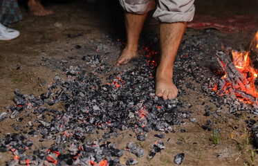 Walking on the burning cinders close-up side view.