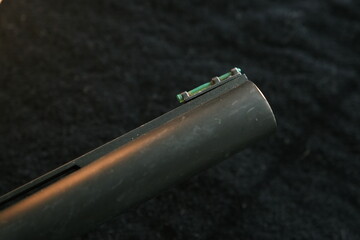 Muzzle of shotguns. Shotgun - macro shooting. Muzzle end of the barrel with green bead on the end...