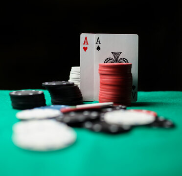 two aces in on the green gaming table, close-up. Concept Image of a poker table. two aces, two playing cards and poker chips on a green casino table, on a black background. success in gambling.