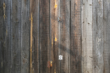 The texture of an old fence with a shadow. Wood texture with vertical lines. The texture of wood with knots and holes. The background of a fence damaged by time.