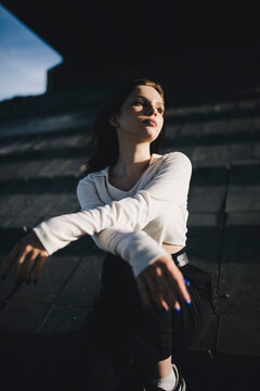 urban lonely girl sitting under a dark bridge