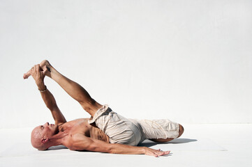 Man practicing perfect yoga photographed against a white background. 