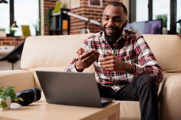 African american man using online videocall conference with business people, talking on remote videoconference call. Chatting on webcam teleconference business meeting on laptop at home.