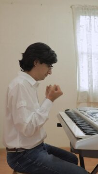 man doing stretching exercises for the hands before starting to play the keyboard