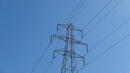 Electricity pylon against deep blue sky with space for copy
