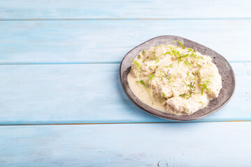 Stewed chicken fillets with coconut milk sauce. side view, copy space.