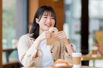 カフェでドーナツを食べる若い女性
