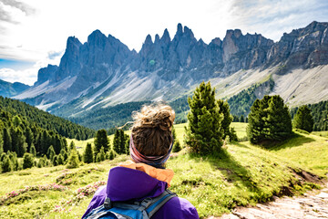 Athletic woman enjoys view from beautiful hike trail at Seceda in the dolomites at noon. Seceda,...
