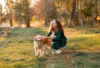 Closeup of curly woman embracing with her dog in spring time season