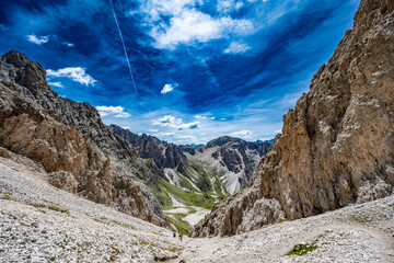 View from hiking trail pass at Seceda mountains into vally at noon. Seceda, Saint Ulrich, Dolomites, Belluno, Italy, Europe.