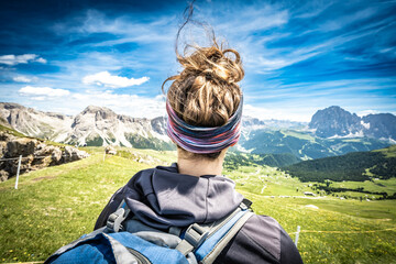 Athletic woman enjoys view from beautiful hike trail at Seceda in the dolomites in the afternoon....
