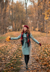 Portrait of pretty girl walking on the background yellow leaves