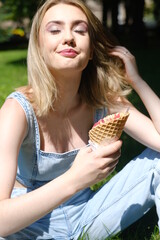 Girl in the blue jeans denim eating red ice cream