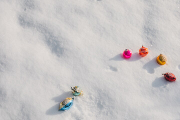 Pink, orange, yellow, blue vintage christmas tree ornaments on fresh white snow