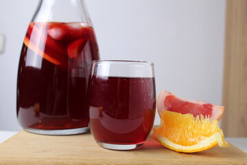 red drink juice grape red wine in a glass of sangria in a glass next to lie fruit oranges grapefruit close-up. drinks for the winter cold. Warming drinks holiday atmosphere