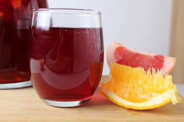 red drink juice grape red wine in a glass of sangria in a glass next to lie fruit oranges grapefruit close-up. drinks for the winter cold. Warming drinks holiday atmosphere